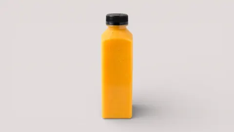 Gelber Smoothie in einer Flasche